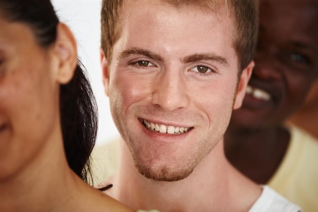 A close-up of a person's face showing a genuine smile, with crinkling around the eyes, demonstrating authenticity and trustworthiness in nonverbal communication.