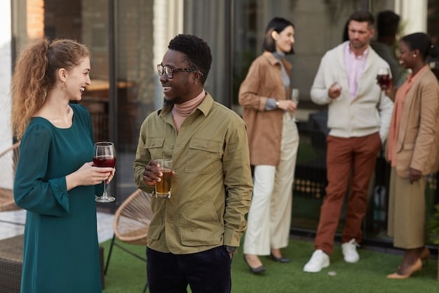 A diverse group of people at a networking event, with some individuals actively engaged in conversation while others are exchanging business cards. The atmosphere is positive and professional, showcasing the opportunity to build connections and expand networks.