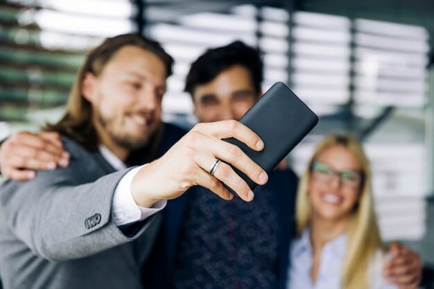 A close-up shot of a business card exchange between two entrepreneurs at a networking event in Silicon Valley, California. The background is blurred, showing other attendees mingling.